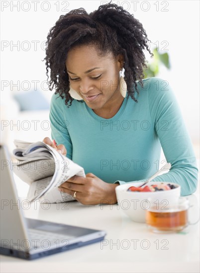 African woman reading newspaper