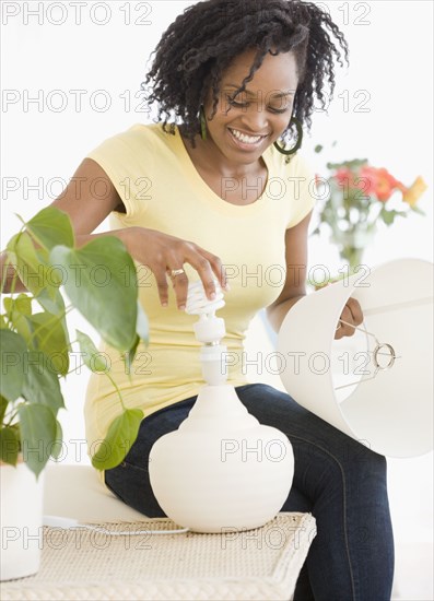 African woman changing light bulb