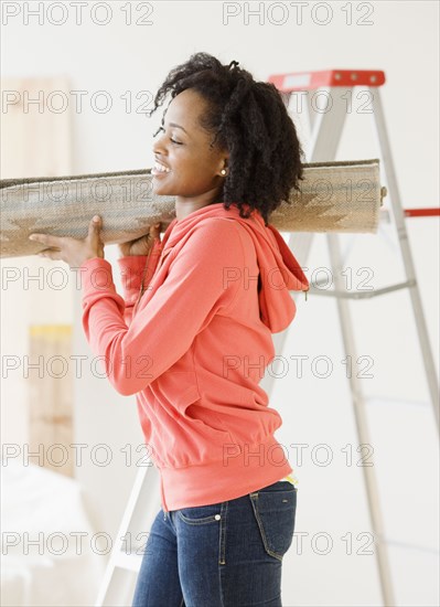 African woman carrying rug