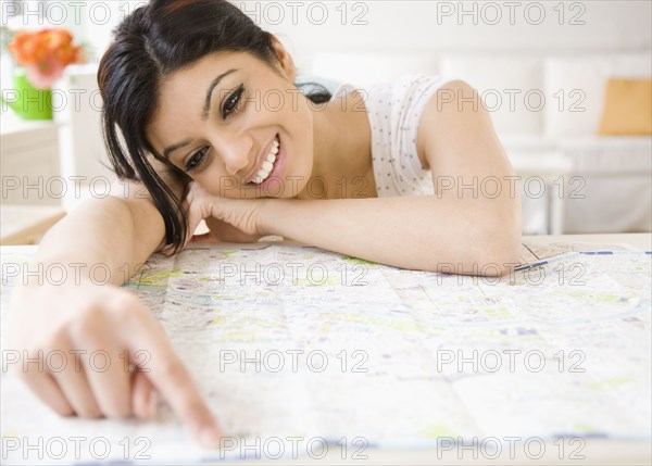 Mixed Race woman pointing to map