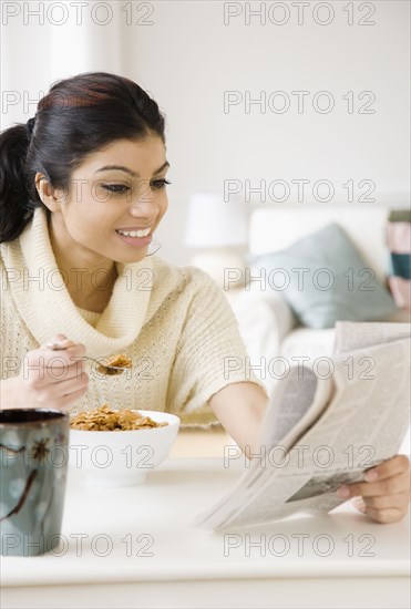 Mixed Race woman eating breakfast