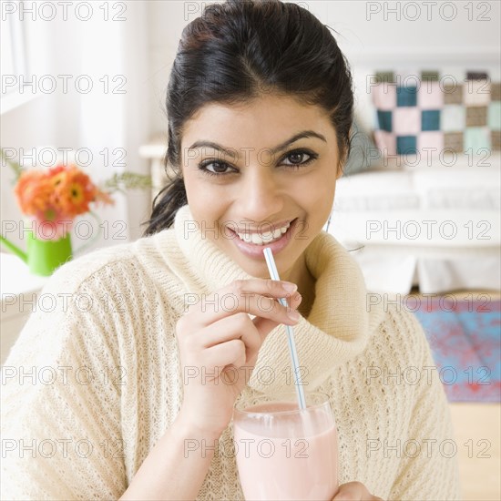 Mixed Race woman drinking milkshake