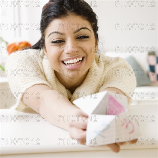 Mixed Race woman holding origami fortune teller