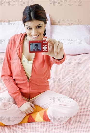 Mixed Race woman taking own photograph