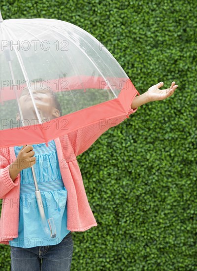 Mixed race girl with umbrella in the rain