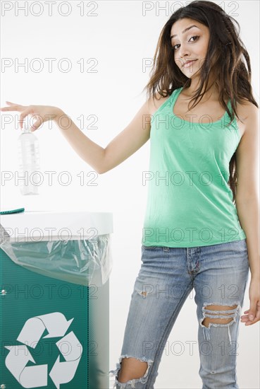 Middle Eastern woman recycling plastic bottle