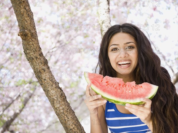 Middle Eastern woman eating watermelon