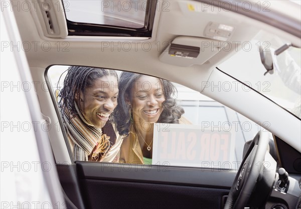 African couple looking at car for sale