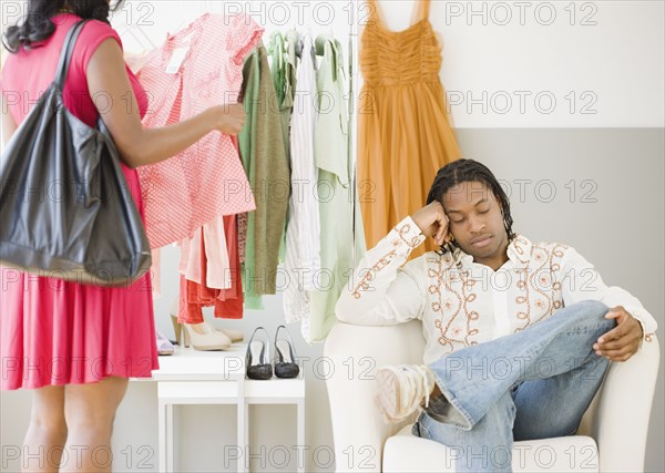 African man bored while woman shops