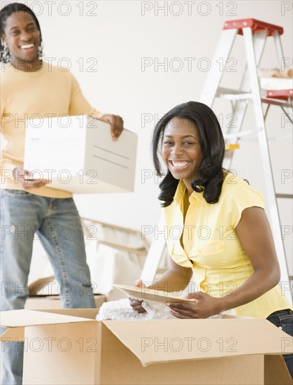 African couple packing moving boxes