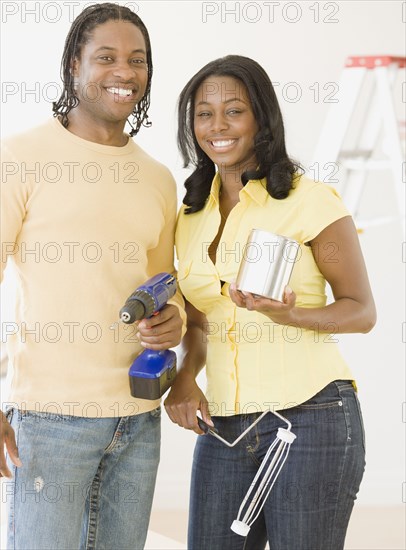 African couple holding home improvement tools