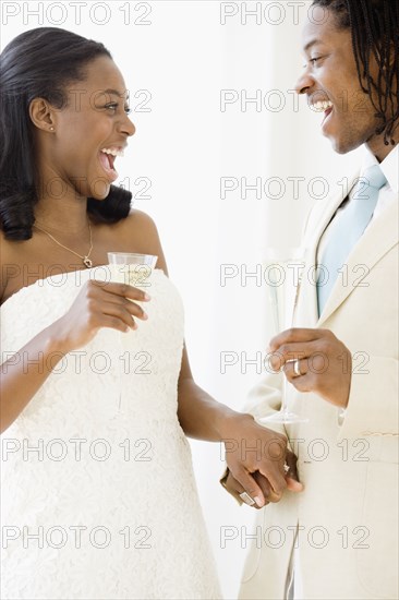 African bride and groom holding champagne flutes