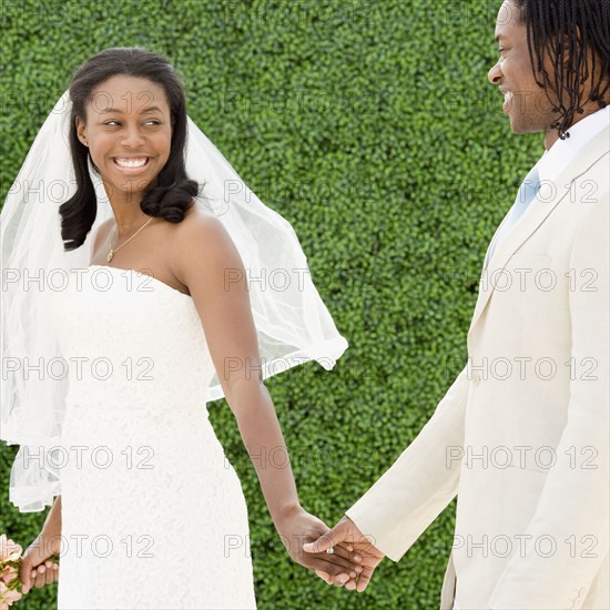 African bride and groom holding hands walking