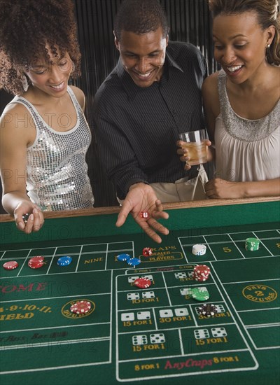 African man and women playing craps at casino