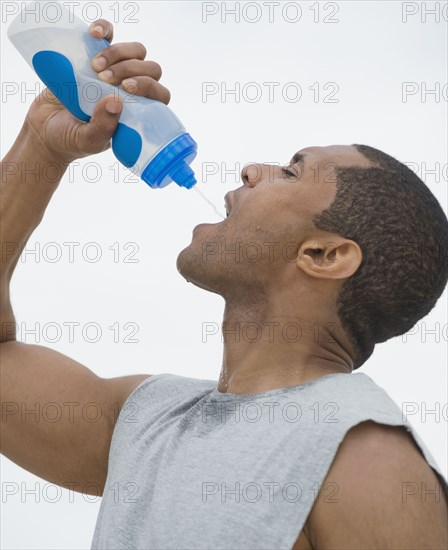 African man drinking from water bottle