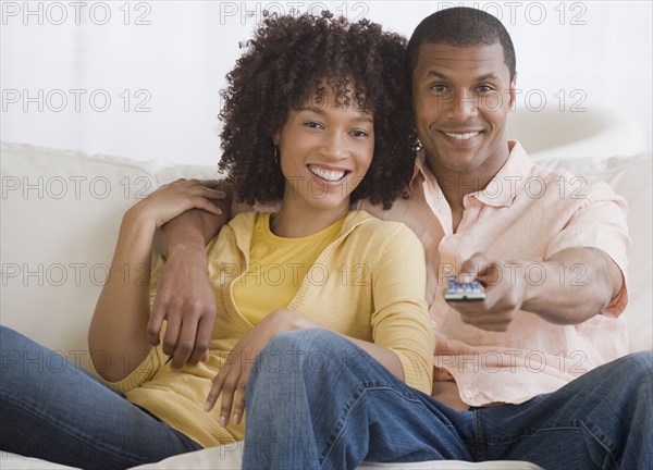 African couple watching television