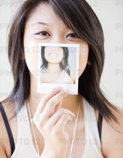 Asian woman with instant photograph of herself