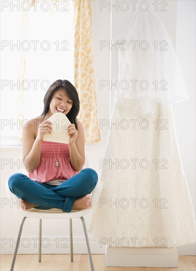 Asian woman licking wedding invitation