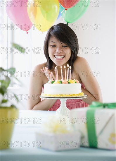 Asian woman about to blow out birthday candles