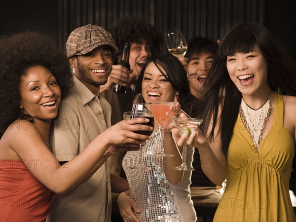 Multi-ethnic friends drinking in nightclub