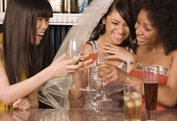 Multi-ethnic friends drinking in nightclub for bachelorette party