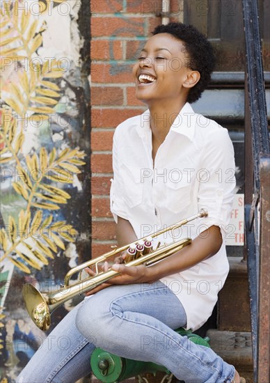 African woman holding trumpet outdoors