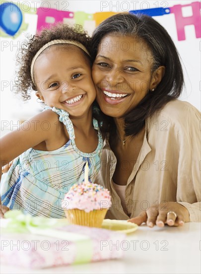 African grandmother hugging granddaughter on her birthday