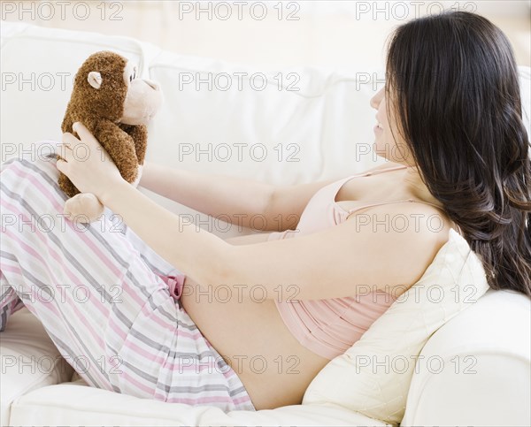 Pregnant Asian woman holding stuffed animal