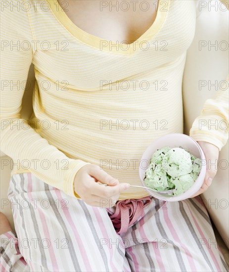 Pregnant Asian woman eating ice cream