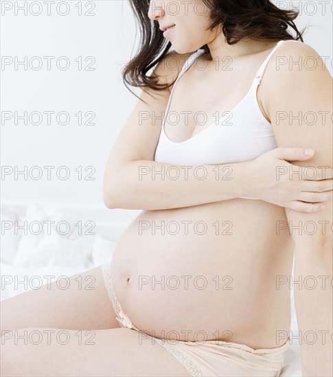 Pregnant Asian woman in bra and underwear