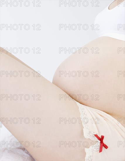Pregnant Asian woman in bra and underwear