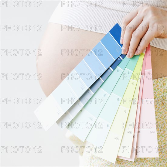 Pregnant Asian woman holding several color swatches