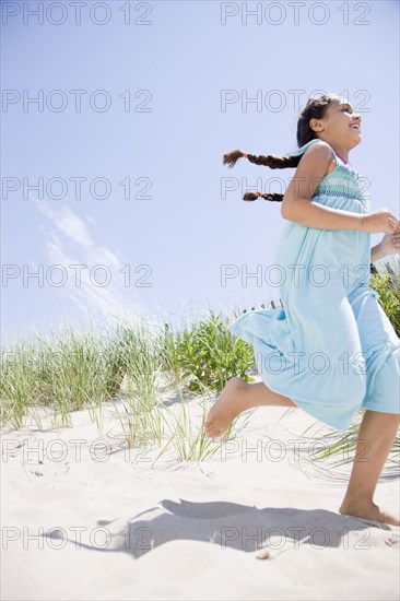 Hispanic girl running at beach