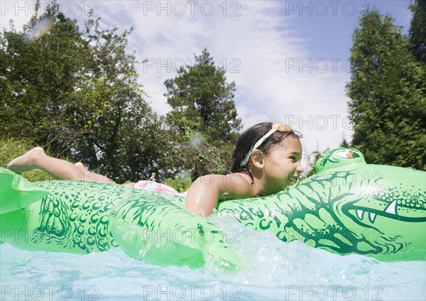 Hispanic girl playing in swimming pool