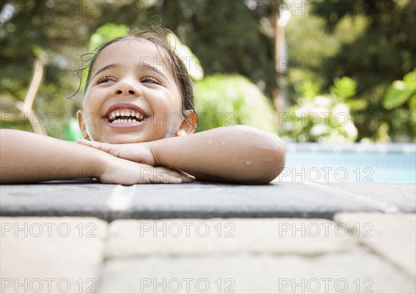 Hispanic girl resting at poolside