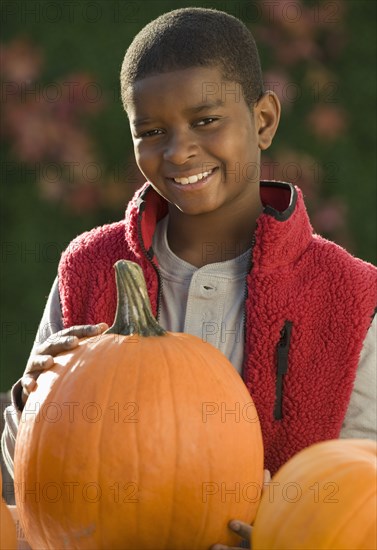 African boy holding pumpkin
