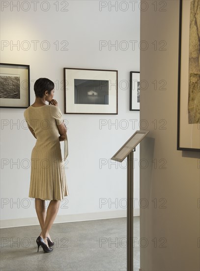 African woman enjoying photographs in museum