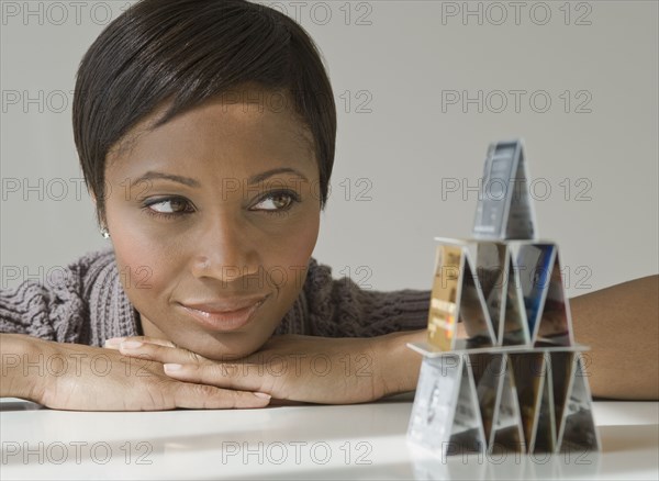 African woman looking at pyramid of credit cards