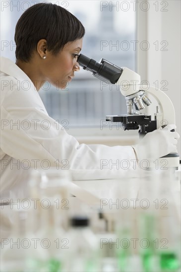 African scientist peering into microscope