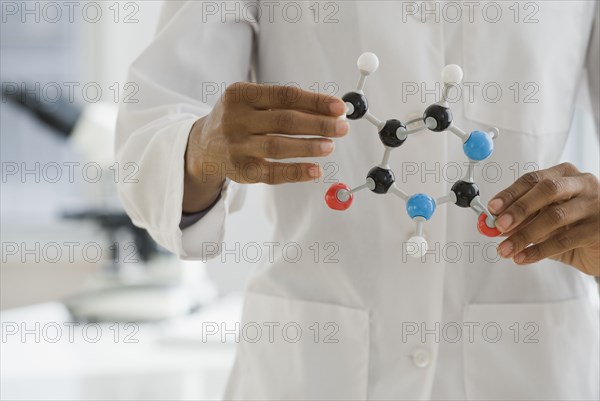 African scientist holding molecule model