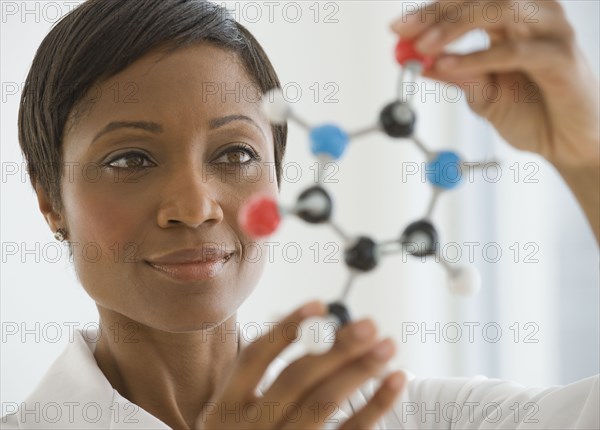 African scientist holding molecule model