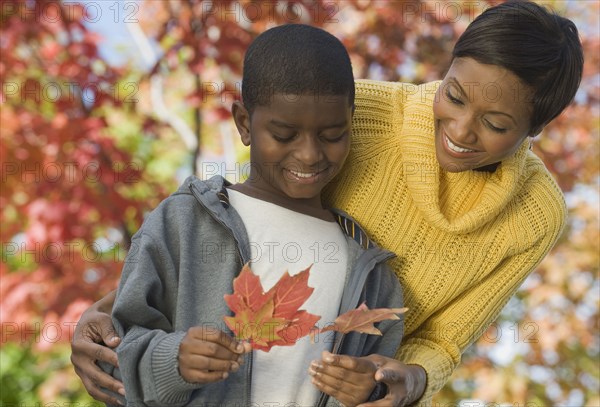 African mother and son looking at autumn leaves