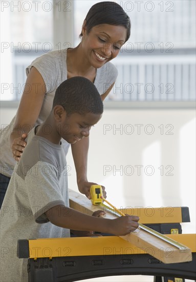 African mother and son woodworking together