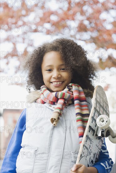 African girl holding skateboard