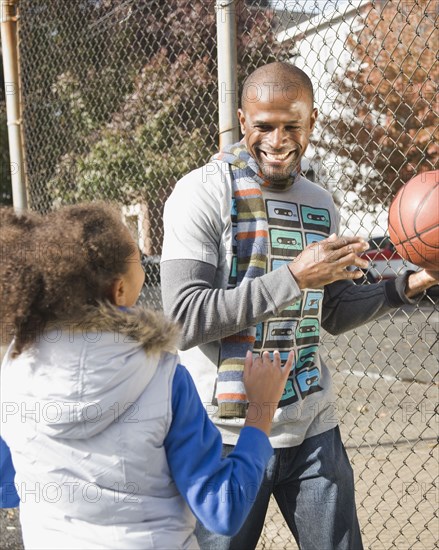 African father and daughter playing basketball