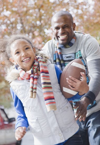 African father and daughter playing football