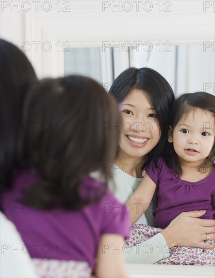 Mother and daughter looking in mirror