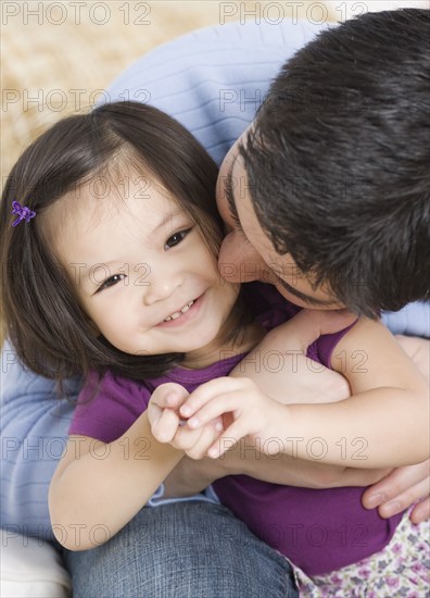 Father kissing toddler daughter