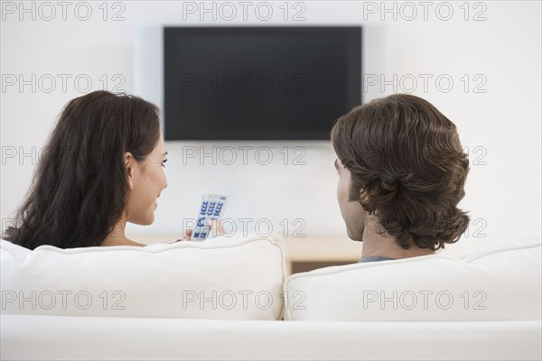 Rear view of couple watching television