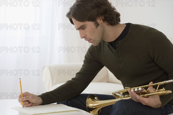 Hispanic man composing trumpet music